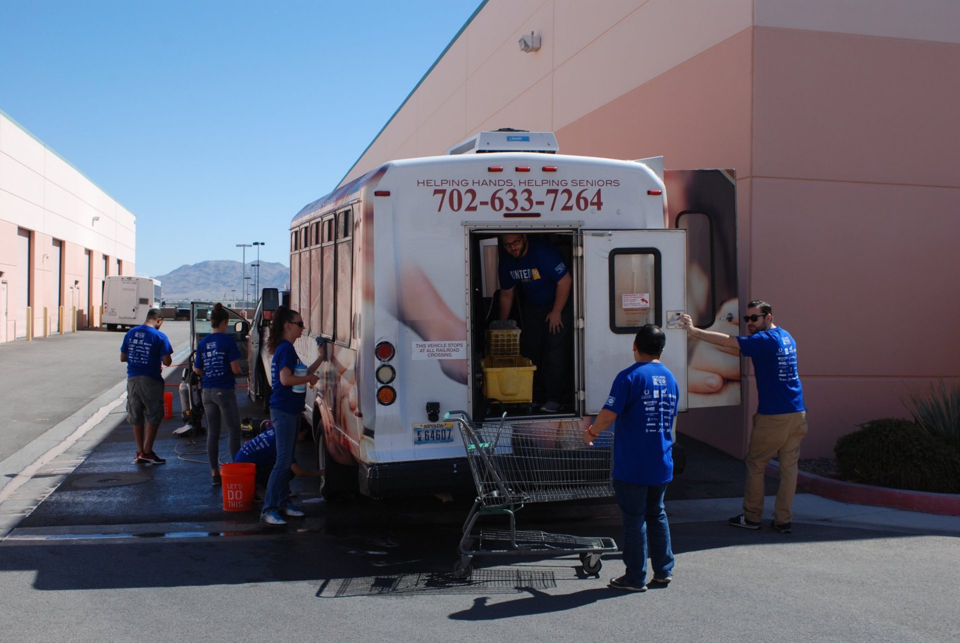 A group of Helping Hands of Las Vegas Valley volunteers work to set-up food deliveries into a 14-passenger bus.