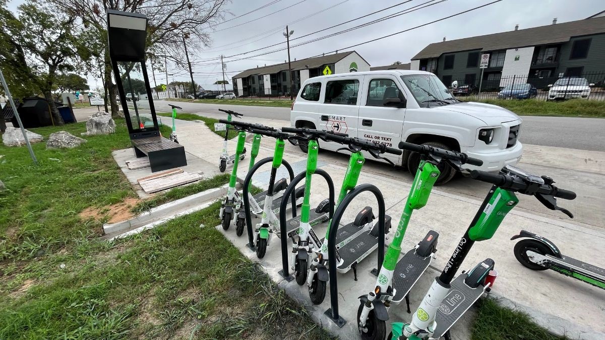 Electric scooters at a bike rack next to a bus shelter at Austin's mobility hub.