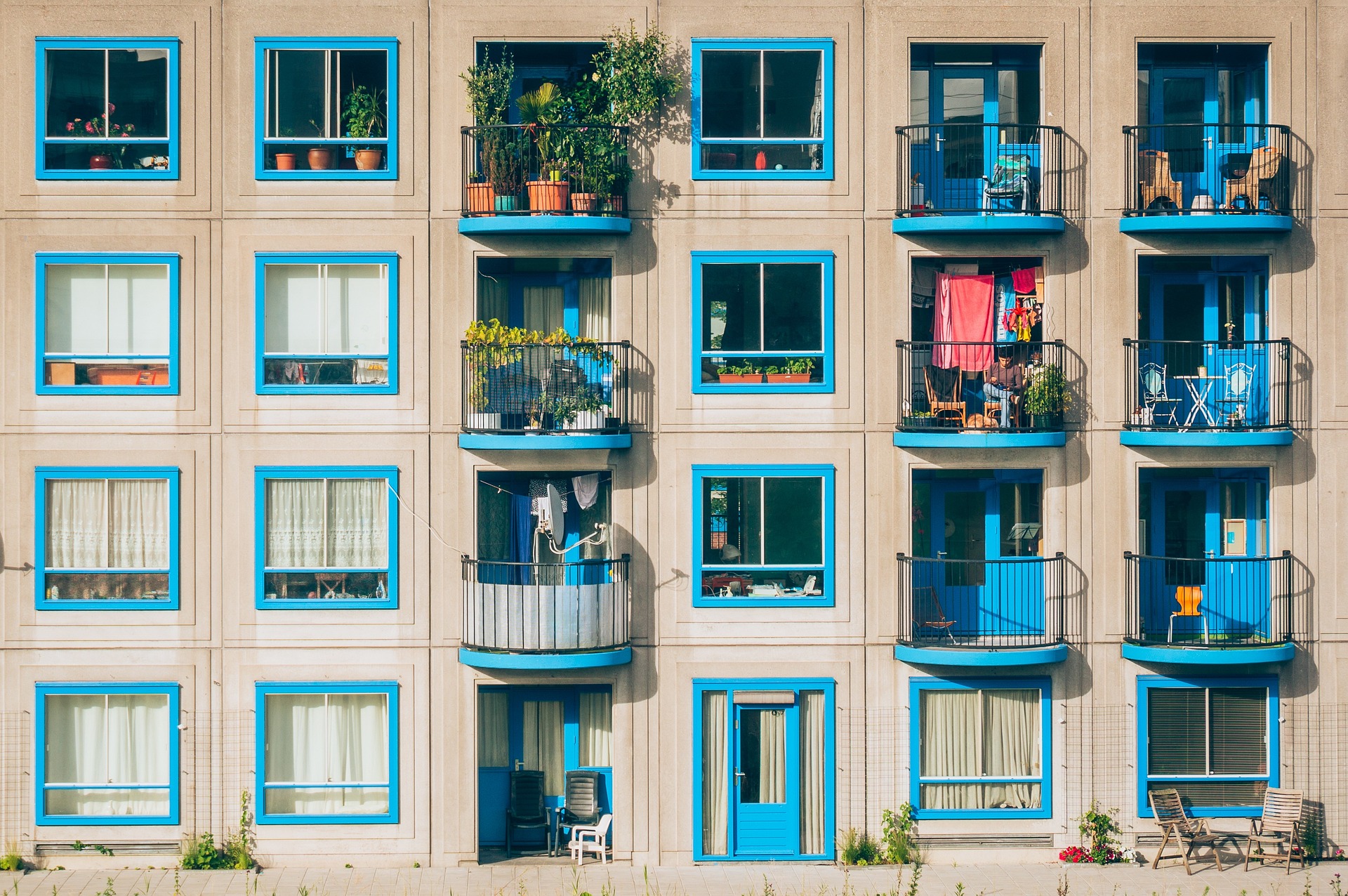 Image of apartment building with blue trim and plants