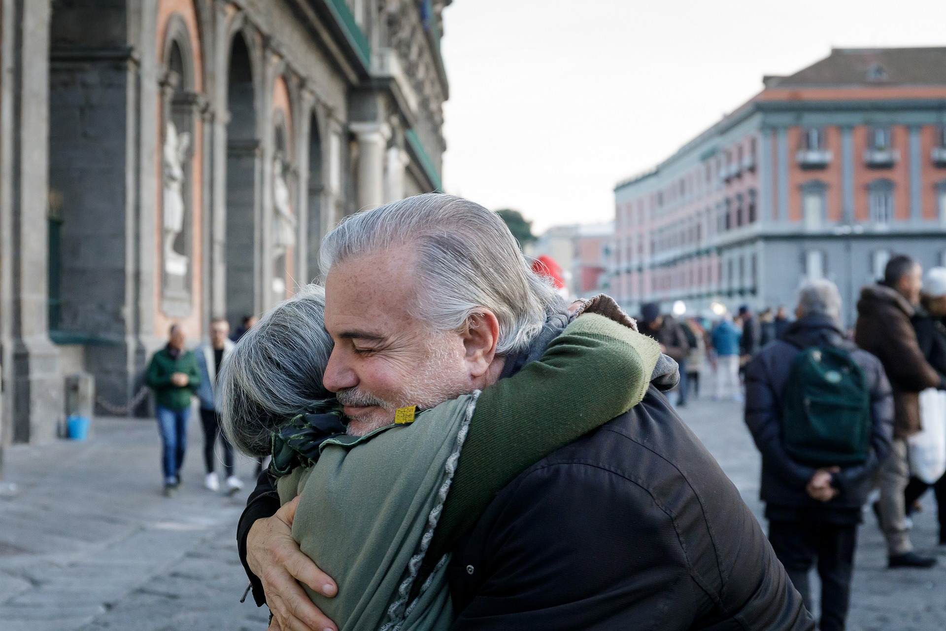 Two people embrace in a street